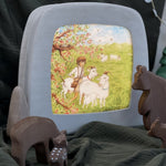 The Toverlux Magic Lamp with an illustration inside by Eentje Van Margo called Little Goat Herder. Looking at the Magic lamp are wooden, toy woodland animals with everything stood on green fabric and a green fabric background
