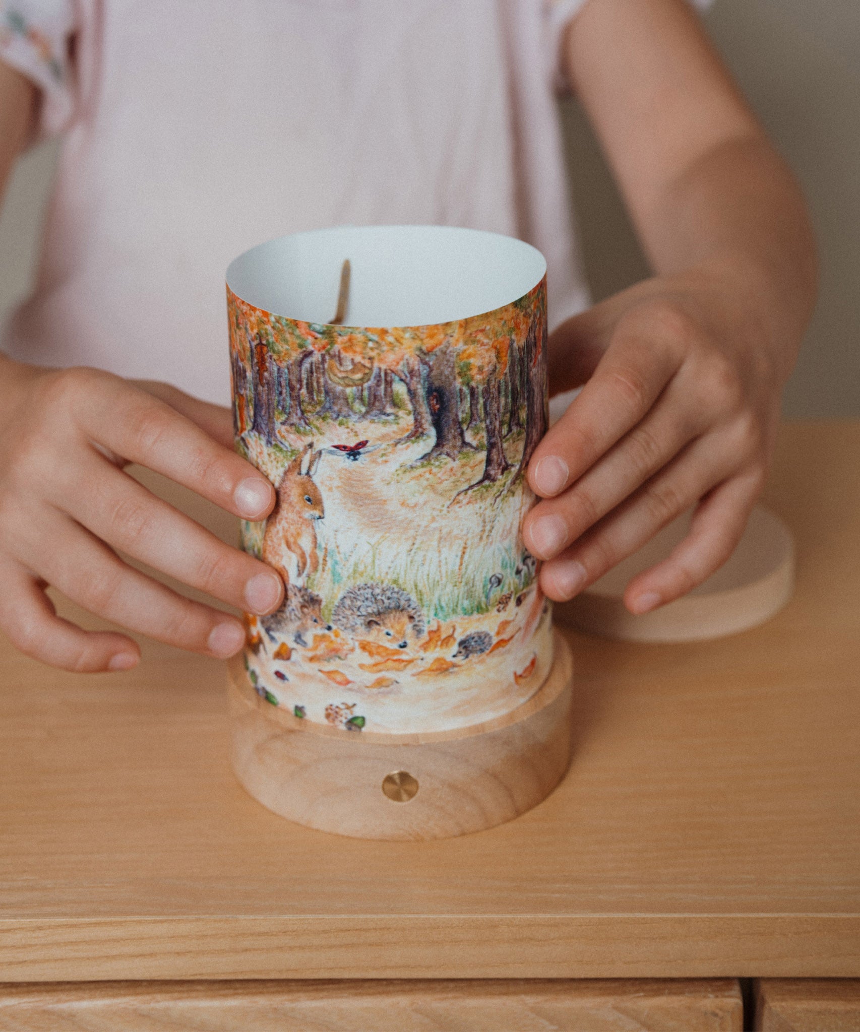 An adult inserting a Eentje Van Margo light wish illustration on the Toverlux rechargeable lantern. Lantern and illustration both available at Babipur. 