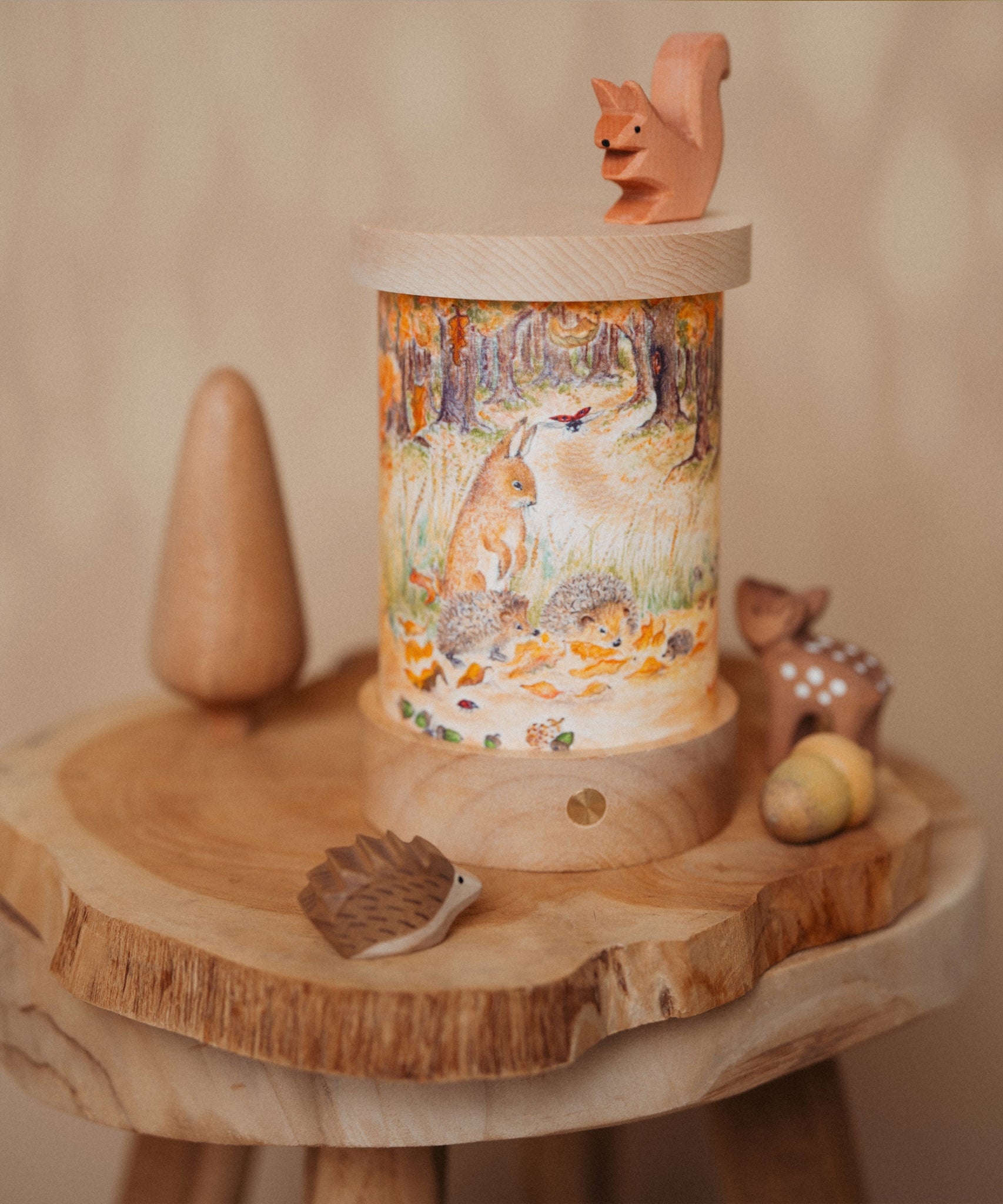 A cosy Autumnal display with various Ostheimer wooden figures and the Toverlux rechargeable lantern with a silhouette inserted. Both the illustration and lantern are available at Babipur.