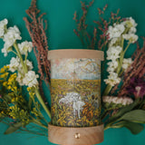 A cosy spring floral inspired flatlay with the Toverlux rechargeable lantern with a silhouette inserted. Both the illustration and lantern are both available at Babipur.