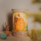 A retro Spring inspired display with Ostheimer rabbits and eggs. The Toverlux rechargeable lantern is on a wooden surface with a light wish illustration inserted the lantern. Both the illustration and lantern are available at Babipur.