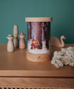 A fully assembled Toverlux illustration and rechargeable lantern displayed with various wooden figures available at Babipur.