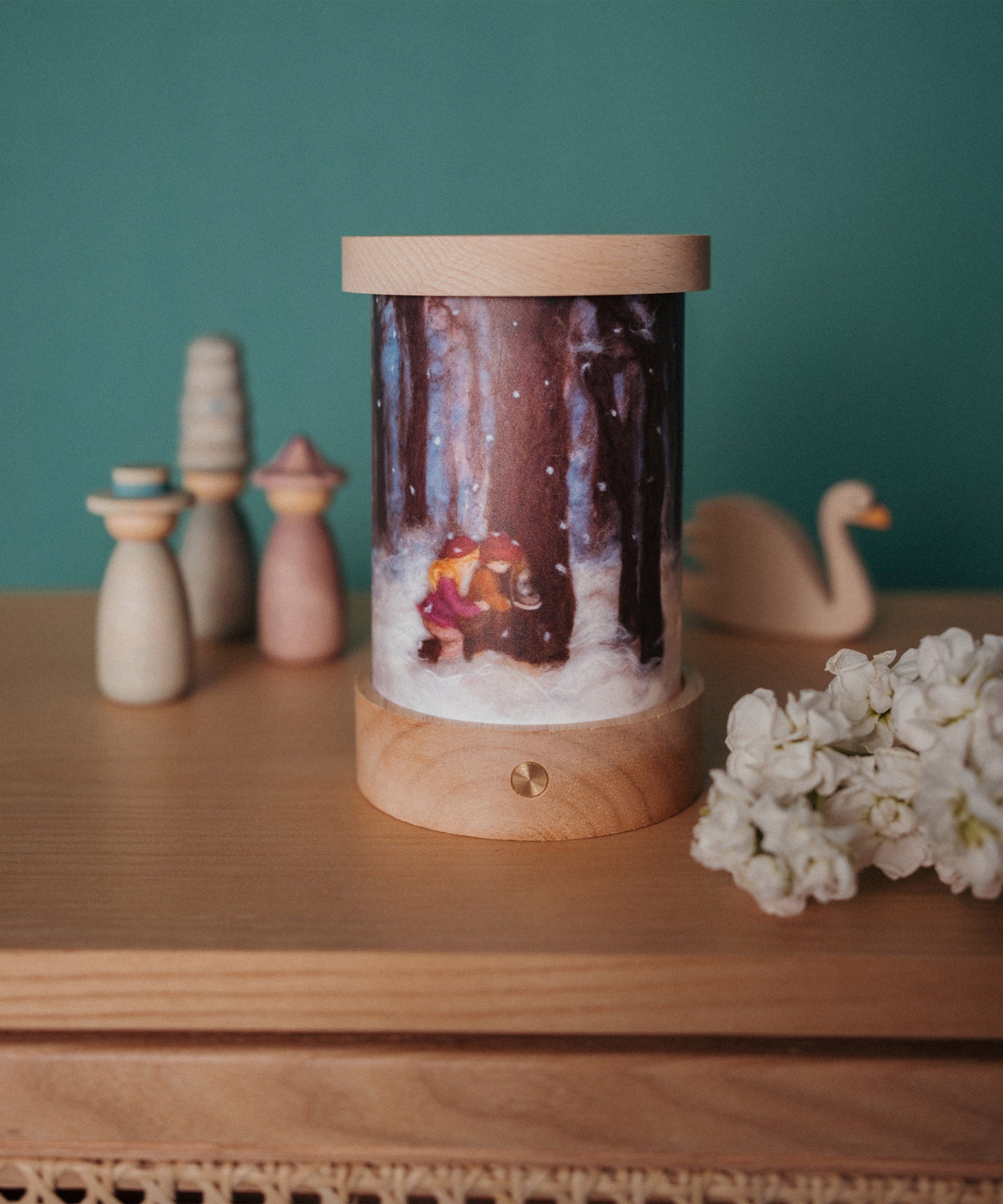 A fully assembled Toverlux illustration and rechargeable lantern displayed with various wooden figures available at Babipur.