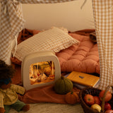 Toverlux Magic Lamp with cosy autumn artwork by Robin Pieterse in a child's den with Nanchen doll.