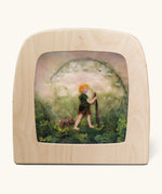 Toverlux Magic Lamp Silhouette - Artwork By Het Wol Feetje, Little Explorer. A felt illustration of a person walking in a grassy area with a rabbit following behind. The image is on a cream background