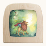 Toverlux Knight silhouette by Anne illustrates that fit in a wooden magic lamp. Shows pencil style of a boy riding a lion and castle in the background