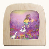 Toverlux little goose girl silhouette by Anne illustrates that fit in a wooden magic lamp. Shows a water colour style of a girl in a purple floral field with geese
