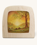 A Toverlux silhouette in the magic lamp with a Autumn leaves silhouette inside by Baukje Exler available at Babipur. A pastel illustration of hedgehogs near mushroom and under a tree with falling autumn leaves