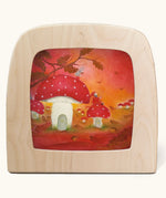 A Toverlux silhouette in the magic lamp with red autumn  artwork by Baukje Exler. An illustration of little toadstool houses.