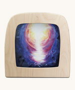 Toverlux hope silhouette by Berit Strasser a oil pastel style of abright light in dark sky. Shows silhouette in a wooden frame