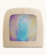 Toverlux light silhouette by Berit Strasser a oil pastel style of mother holding a child. Shows silhouette in a wooden frame