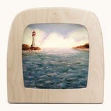 Toverlux lighthouse silhouette by Berit Strasser a oil pastel style of a lighthouse and the ocean. Shows silhouette in a wooden frame