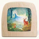 Toverlux Kapitein Kalk - Winter King in Forest Silhouette placed in a magic lamp placed on a table. A beautiful illustration featuring little red hood walking through a forest next to a wolf. 
A range of Toverlux silhouettes, lamps and accessories are available at Babipur.