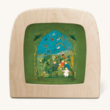 Toverlux magic lamp with a Sibylle Von Olfer Summer silhouette inside, both available at Babipur. Illustration showing a group of children playing in a grassy field with little creatures