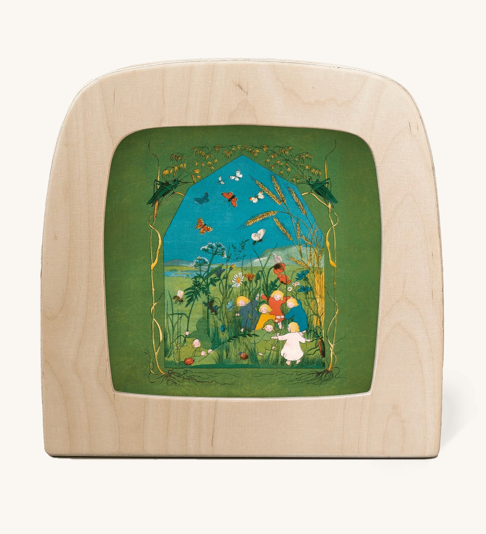 Toverlux magic lamp with a Sibylle Von Olfer Summer silhouette inside, both available at Babipur. Illustration showing a group of children playing in a grassy field with little creatures