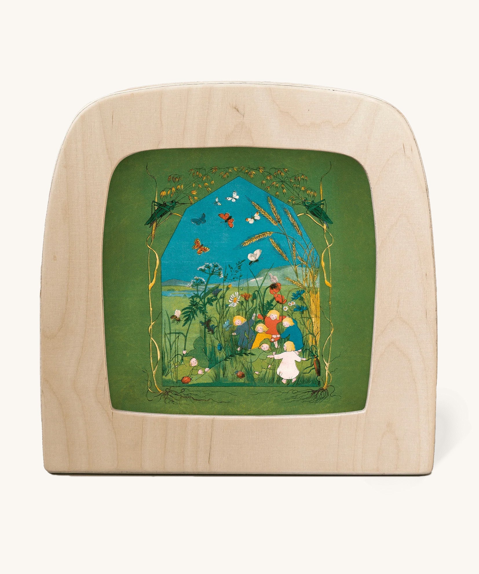 Toverlux magic lamp with a Sibylle Von Olfer Summer silhouette inside, both available at Babipur. Illustration showing a group of children playing in a grassy field with little creatures