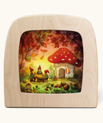 Toverlux magic lamp with a Autumn gnome toadstool picnic silhouette by artist Vogel Geluk. A watercolour style illustration of a toadstool house in a forest with a table with three gnomes sat around it. A range of Toverlux silhouettes, lamps and accessories are available at Babipur. 