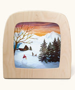 Toverlux magic lamp with a Winter sled song silhouette by artist Vogel Geluk. A watercolour style illustration of a snow covered Winter scene. There is a snowman and children on a sled in the background along with a cosy cottage in the distance. A range of Toverlux silhouettes, lamps and accessories are available at Babipur. 