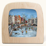 Toverlux Winter canal ice skating Magic Lamp silhouette by artist Gwen van Knippenberg. A watercolour and pencil style illustration of people ice skating on a canal under a bridge.
