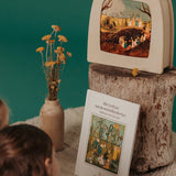 Girls looking at a Toverlux Magic Lamp showing a scene from The Story of Root Children by Sibylle von Olfers.