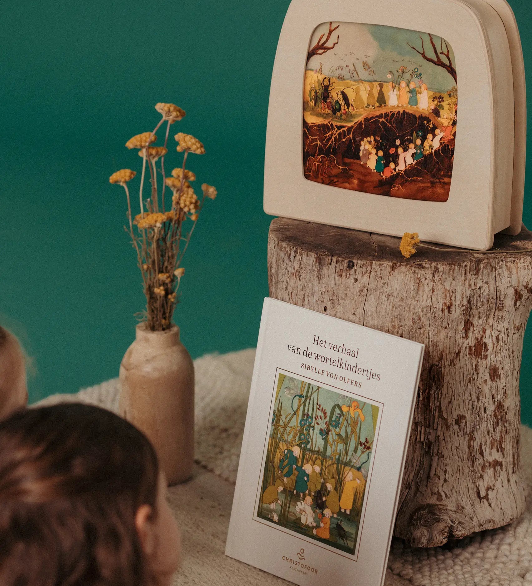Girls looking at a Toverlux Magic Lamp showing a scene from The Story of Root Children by Sibylle von Olfers.