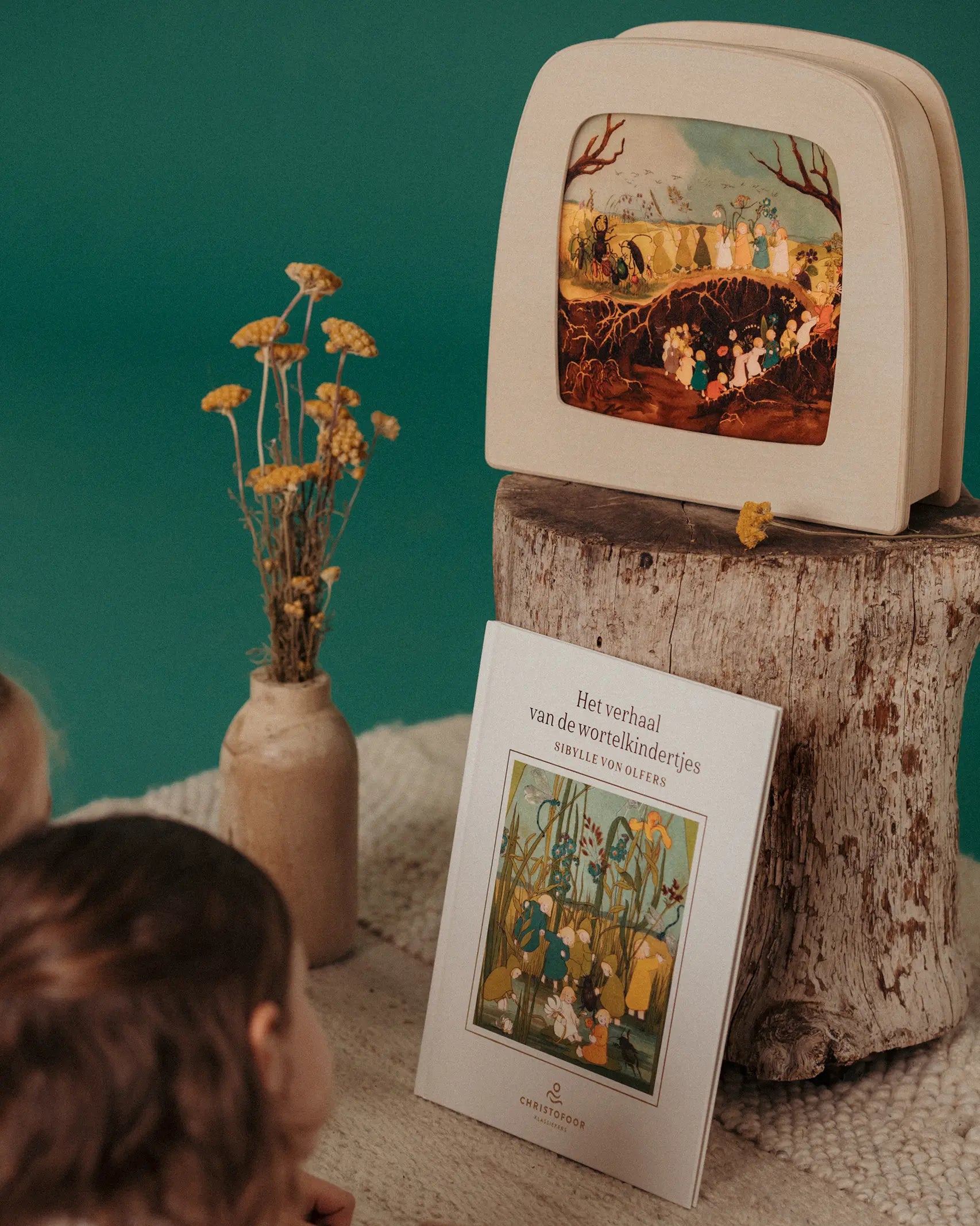 Girls looking at a Toverlux Magic Lamp showing a scene from The Story of Root Children by Sibylle von Olfers.