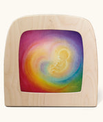 A Toverlux silhouette in the magic lamp with baby in womb rainbow artwork by Baukje Exler. A pastel illustration of a baby in a womb with a dreamy rainbow background.