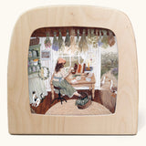 The herbalist Toverlux Magic Lamp silhouette inside a wooden magic lamp. Artwork By Robin-Pieterse. A delicate painting style illustration of a woman reading a book on herbs with a cat and 2 geese standing nearby. This silhouette is available at Babipur