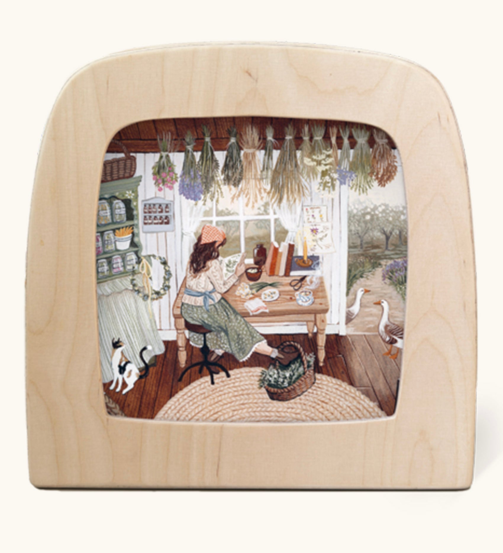 The herbalist Toverlux Magic Lamp silhouette inside a wooden magic lamp. Artwork By Robin-Pieterse. A delicate painting style illustration of a woman reading a book on herbs with a cat and 2 geese standing nearby. This silhouette is available at Babipur