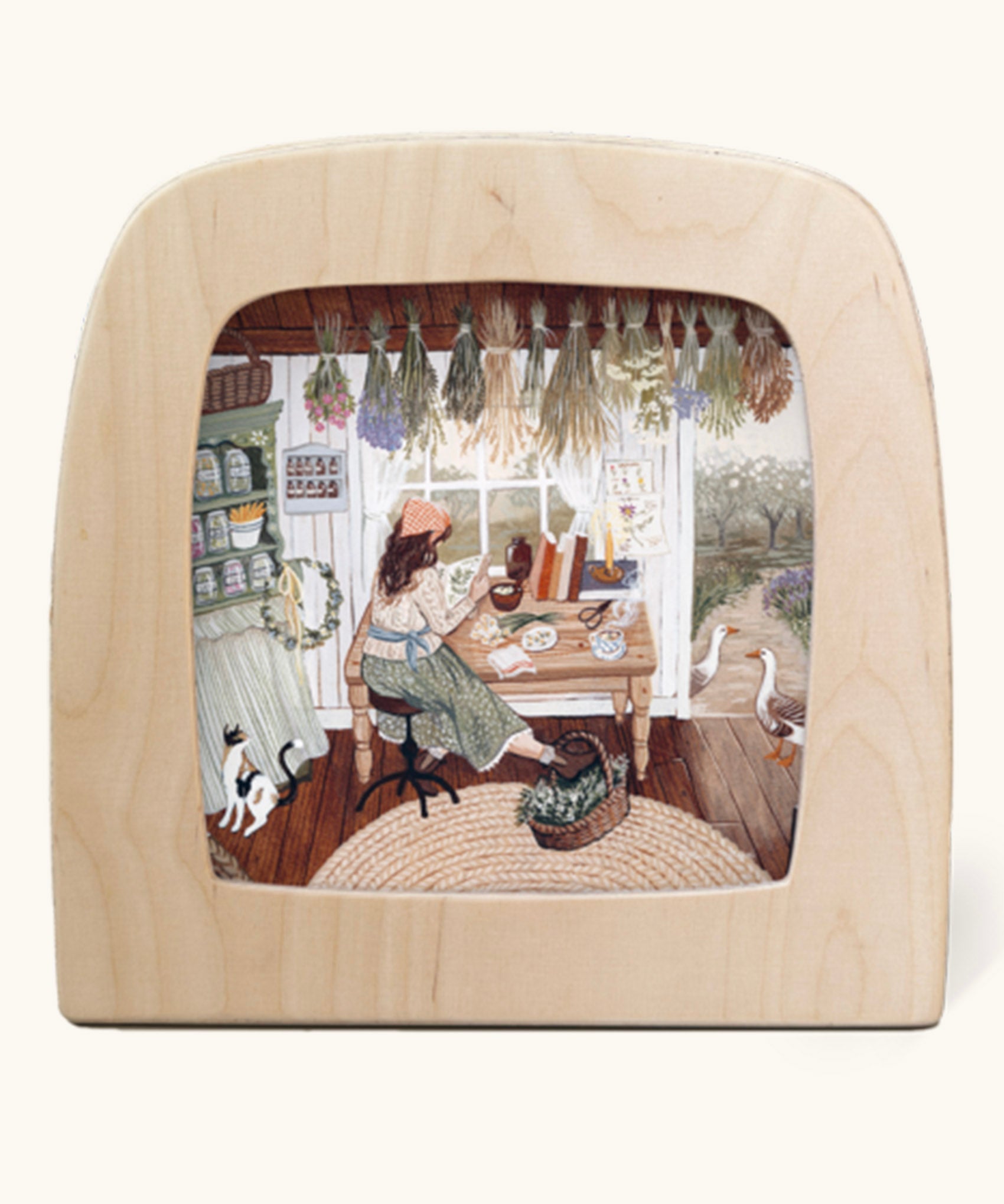 The herbalist Toverlux Magic Lamp silhouette inside a wooden magic lamp. Artwork By Robin-Pieterse. A delicate painting style illustration of a woman reading a book on herbs with a cat and 2 geese standing nearby. This silhouette is available at Babipur