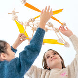 Children holding up a helicopter made from various wooden poles and blocks out of the Trigonos mini large construction set 