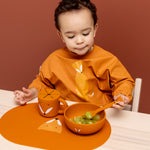 Toddler eating chopped grapes from the Trixie Animal Friends Silicone Suction Bowl, orange, Mr Fox. 