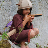 A child in full Viking costume including the Vah Viking Tunic, helmet and drinking horn. The child is playing with a cross bow.