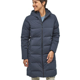 Person wearing a long blue puffer coat on a white background