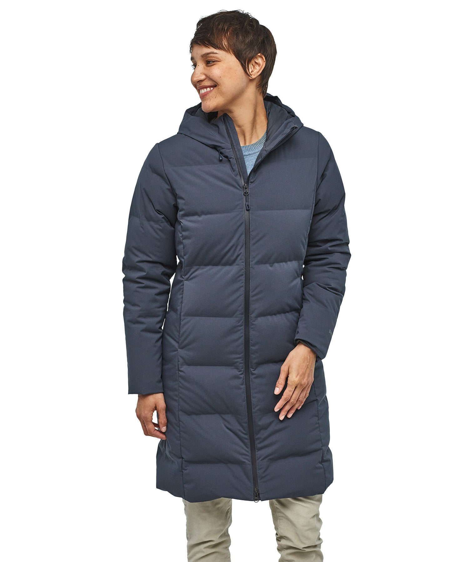 Person wearing a long blue puffer coat on a white background