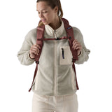 A view of the front of a woman wearing The Patagonia Black Hole Pack 32 litre capacity backpack in dulse mauve colour on her back.