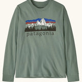 Patagonia Kids organic cotton Long-Sleeved Graphic T-Shirt in Cover Green. A sage green body with a vintage-style Patagonia Fitz Roy Foothills logo on the chest.