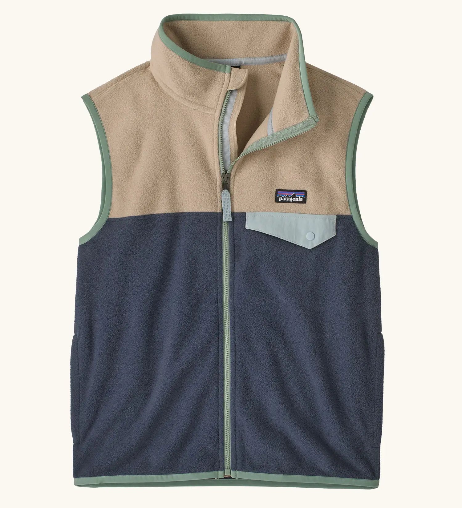 Patagonia Kids Micro D Snap-T Fleece Vest in Smolder Blue with Oar Tan. Navy blue lower body panel, camel beige upper panel, and sage green binding with a matching chest pocket flap.
