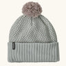Patagonia Kids Powder Town Beanie in Confetti: virtually blue. A Light grey knit with pink and navy dots, a rib knit cuff, and a pale pink pom-pom on top. With a small vertical Patagonia logo on the cuff.