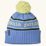Patagonia Kids Powder Town Beanie in Park Stripe: Diver Blue. A pale blue knit with lime green 'Patagonia' woven around the head, a rib-knit cuff, and a lime green pom-pom on top. 