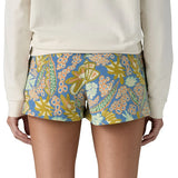 Back of woman wearing Patagonia's quick drying barely baggies shorts in blue with a repeating abstract floral design. 