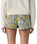 Back of woman wearing Patagonia's quick drying barely baggies shorts in blue with a repeating abstract floral design. 