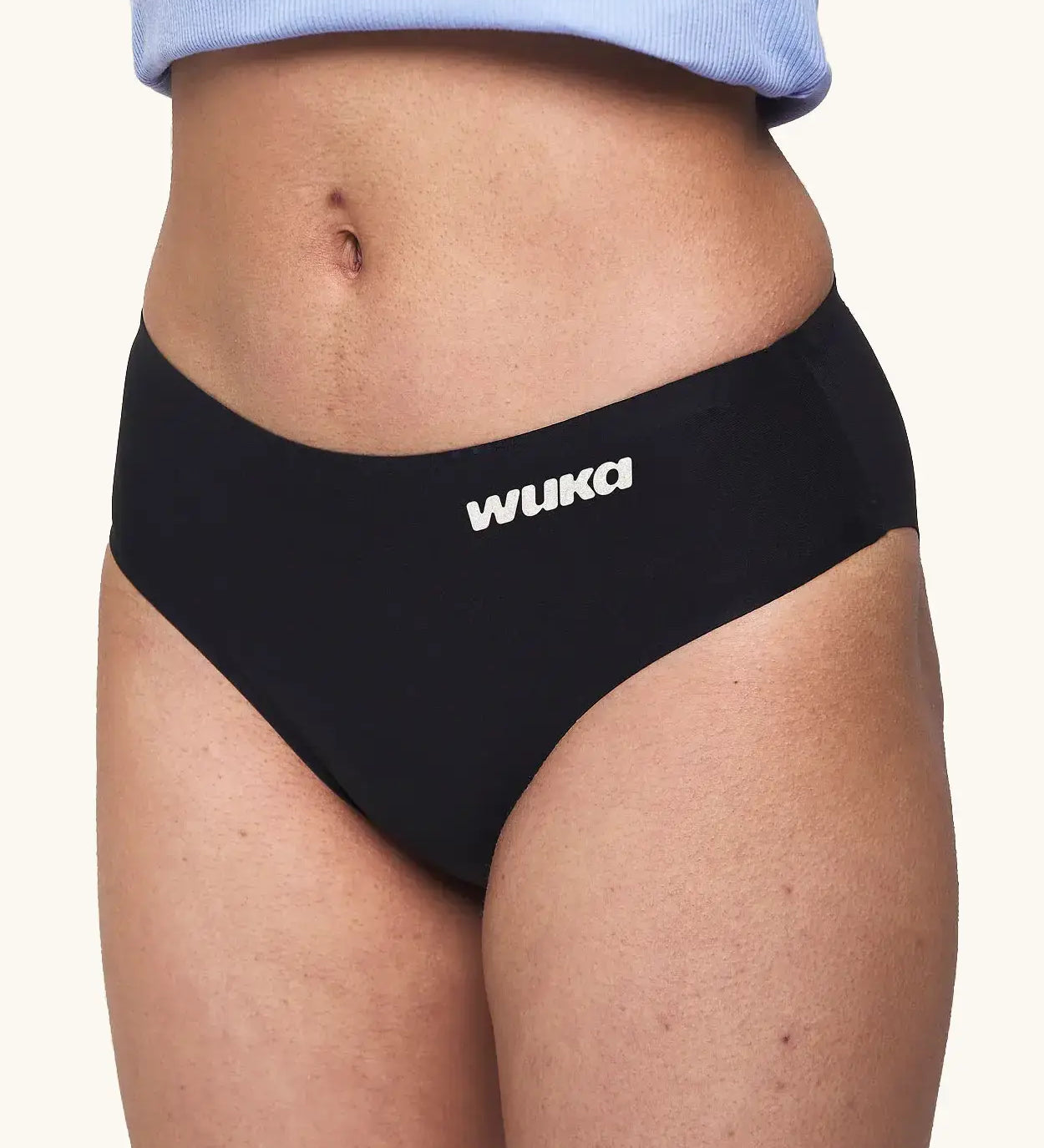 Side of model wearing the WUKA Teen Stretch Bikini Brief Period Pants showing the white branding 