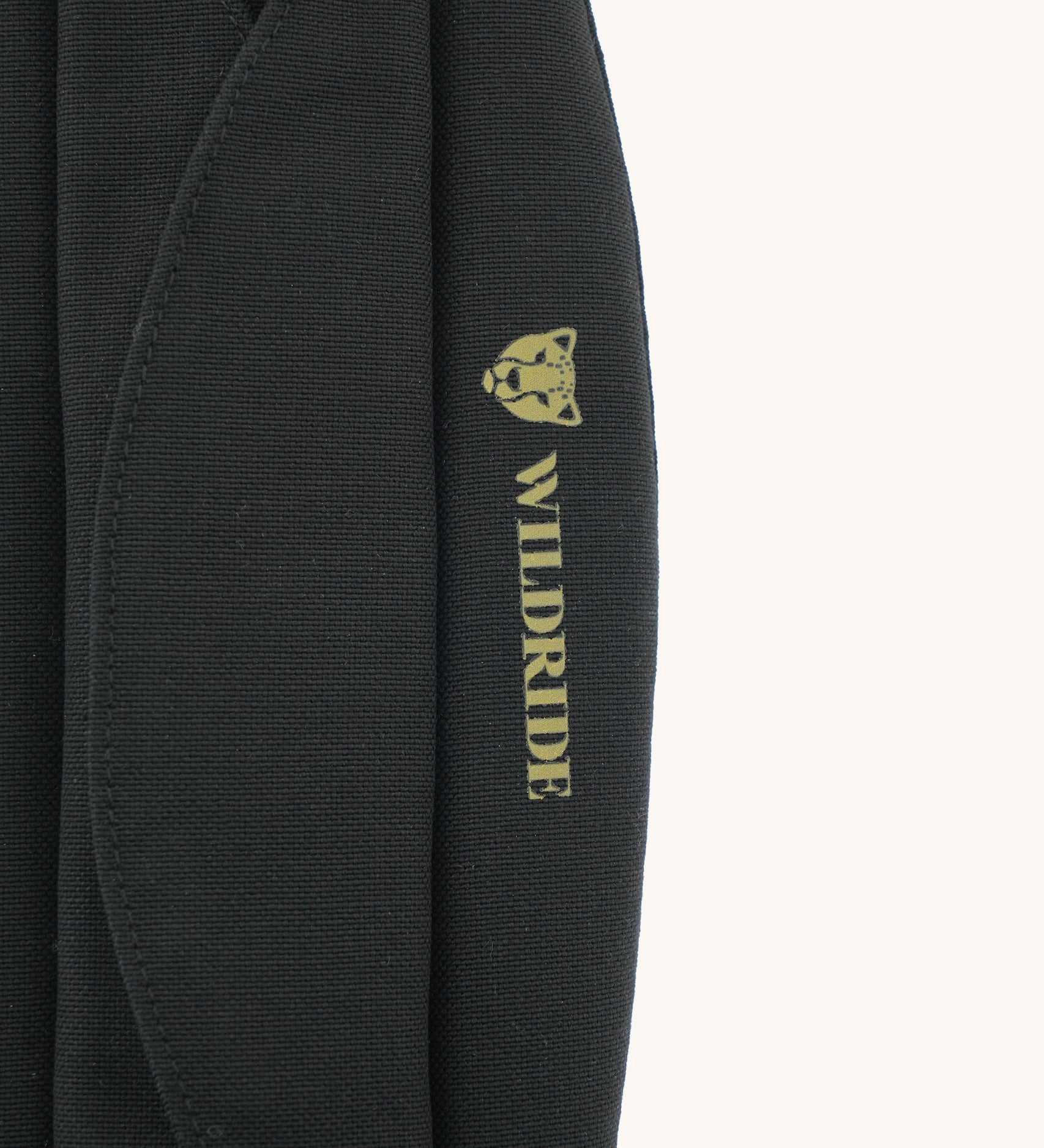 A close up of the Wildride premium shoulder pad in black available at Babipur showing the velcro and brand logo detail