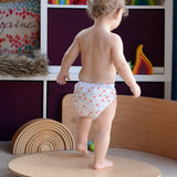Wobbel 360, a wooden circle balance board toy for children with felt backing, being played with by child in a playroom.