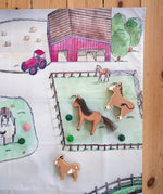 Wonderie cotton play cloth with farm design featuring a horse paddock with Ostheimer and Lanka Kade toy horses.