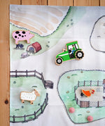 Wonderie cotton play cloth with farm design featuring a pig stye and chicken coops with Lanka Kade farm figures.