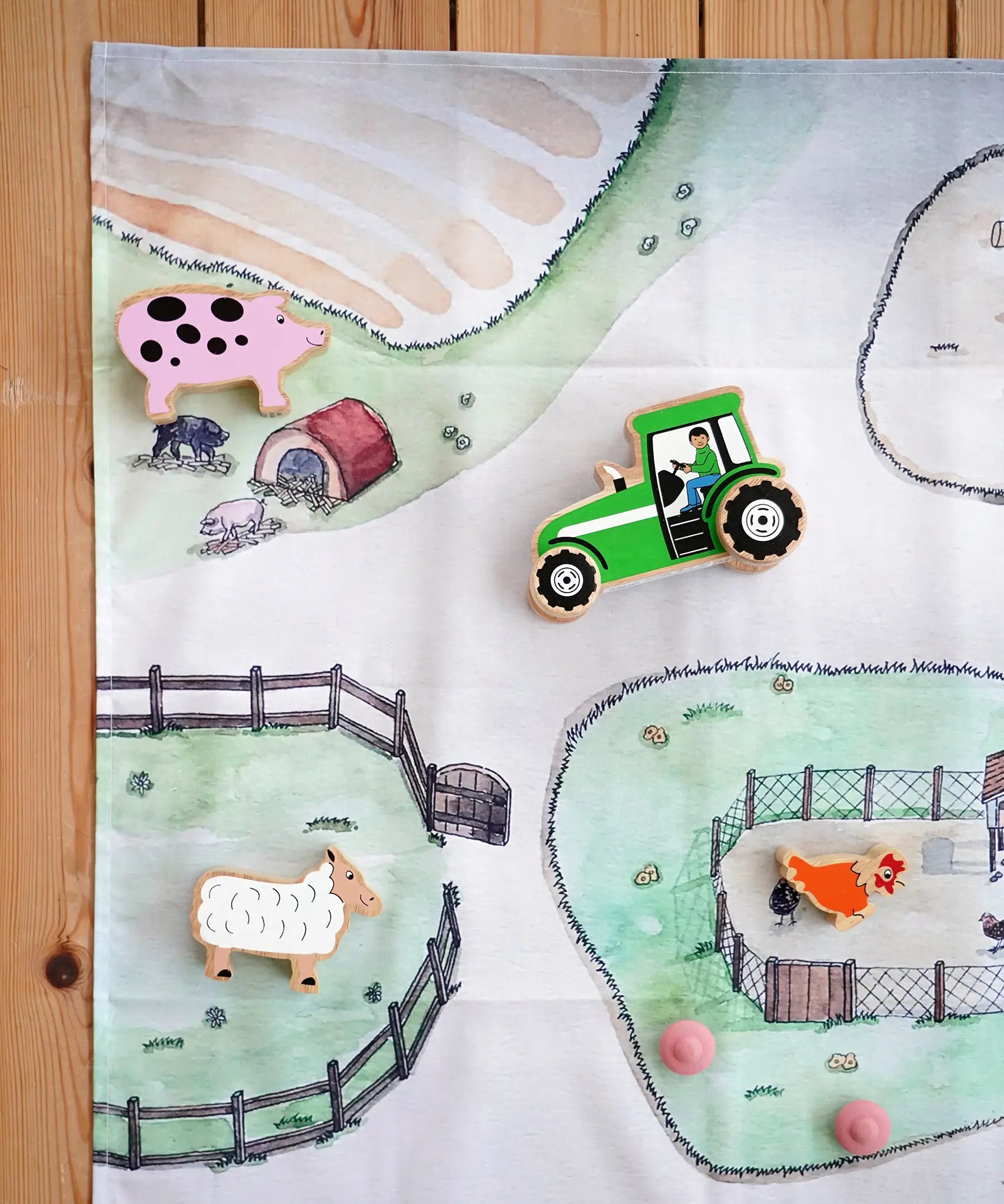 Wonderie cotton play cloth with farm design featuring a pig stye and chicken coops with Lanka Kade farm figures.
