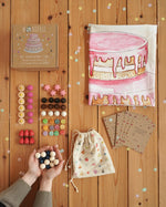 Wonderie everlasting birthday cake play cloth with Grapat 60 wooden play pieces, a drawstring bag and cotton drawstring bag.