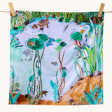 Wonderie Play Cloth - Down By The Pond. A beautiful play cloth depicting a busy pond scene with ducks, frogs, a heron, fish and dragonflies all playing among the reeds and lily pads